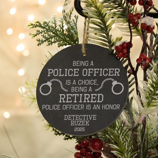 Personalized ornament fora a retired police officer, hanging on a Christmas tree.