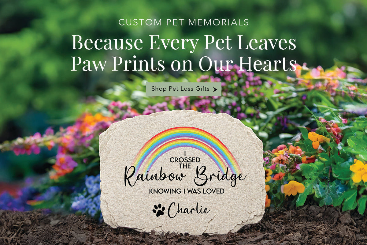 Memorial pet loss garden stone with rainbow and text in a garden setting