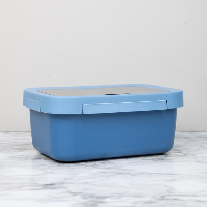 Blue lunch box side view on a marble surface