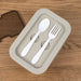 Spoon and fork set in a beige lunch box on a wooden surface