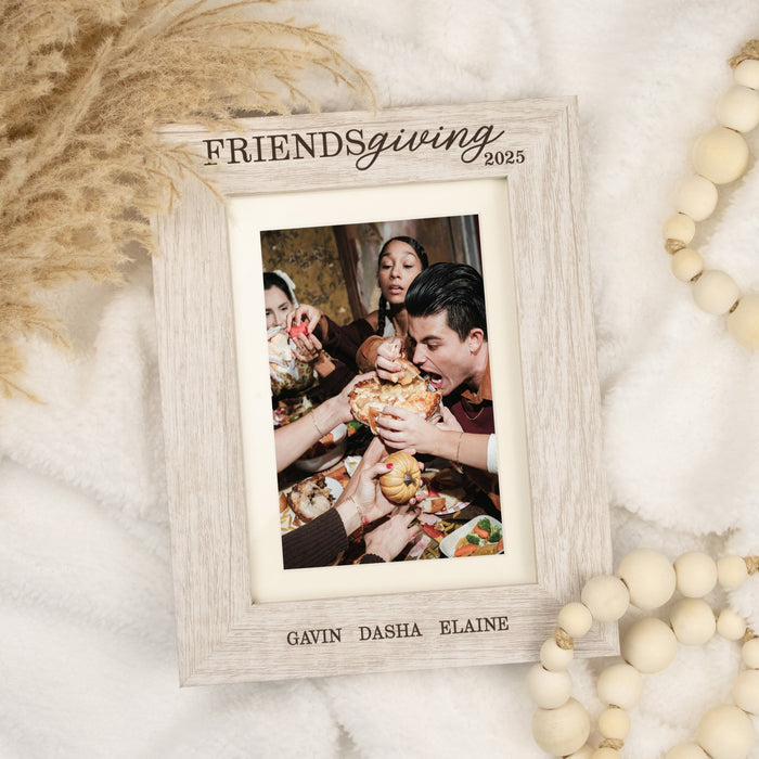 Wooden photo frame with 'Friendsgiving 2025' text and a family photo inside, on a decorative background.