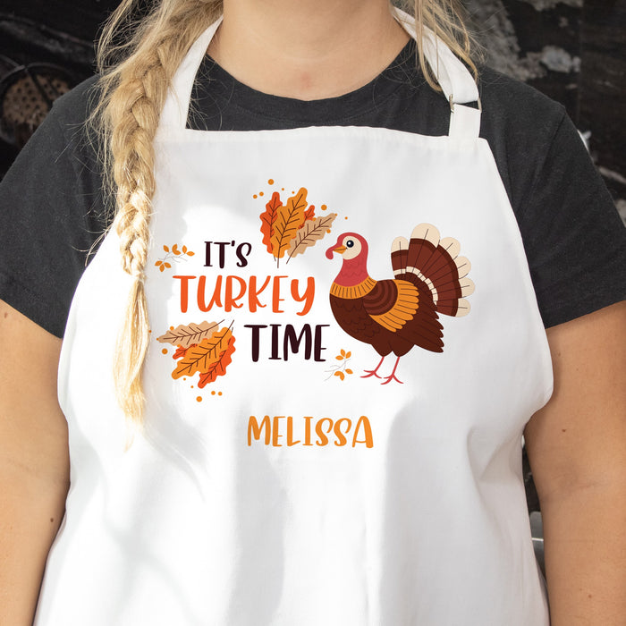 Person wearing a personalized Thanksgiving apron with 'It's Turkey Time' text and turkey design.