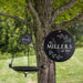 custom bird bath with monogram of last name and established date hanging from a tree