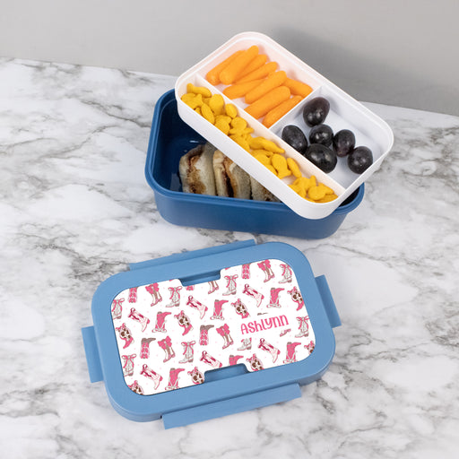 Blue lunch box with a personalized lid featuring western coquette pattern, containing compartments with snacks on a marble surface.