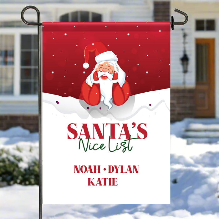 Christmas-themed garden flag with Santa Claus and his nice list with custom names, displayed outdoors in the winter. 