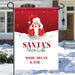 Christmas-themed garden flag with Santa Claus and his nice list with custom names, displayed outdoors in the winter. 