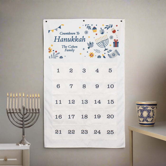 Hanukkah countdown calendar with decorative elements on a wall, next to a menorah and star of david decorative cup.