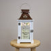 Decorative retirement lantern with floral design and text on a wooden stool against a gray background