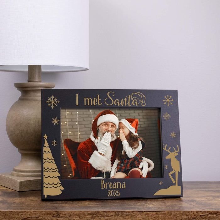 Personalized photo frame with 'I met Santa' text and decorative elements on a wooden surface.