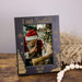 Personalized photo frame with a picture of a child meeting Santa Claus, placed on a wooden surface.
