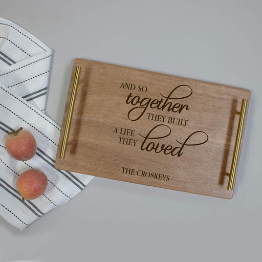 Wooden cutting board with engraved name on a neutral background for wedding gift
