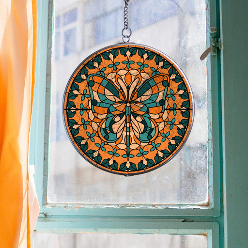 decorative butterfly suncatcher hanging in a blue window with orange curtains
