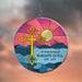 circular stained glass style acrylic suncatcher with personalized memorial and big yellow cross in front of a beach sunrise