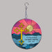 round suncatcher with cross in front of a sunset over the ocean design for memorial
