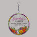 Round hanging suncatcher with floral design and text that reads "grandma's garden" on a gray background