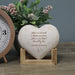 "Love Is A Miracle.." Wooden Heart Display Plaque in wooden holder in front of plant and clock on tabletop